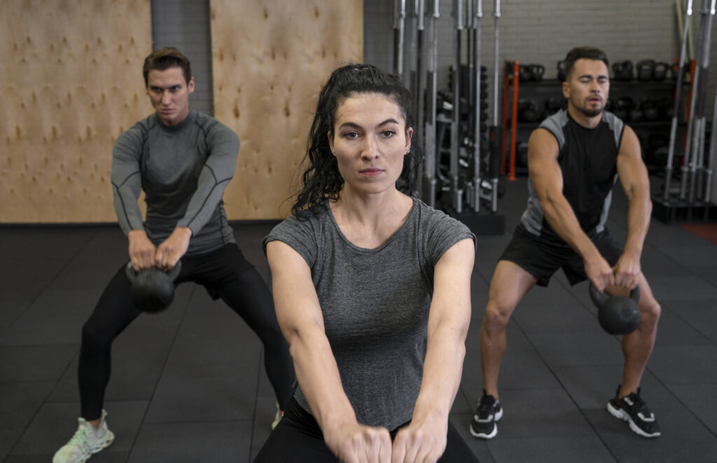 womanworking out with two guys in gym